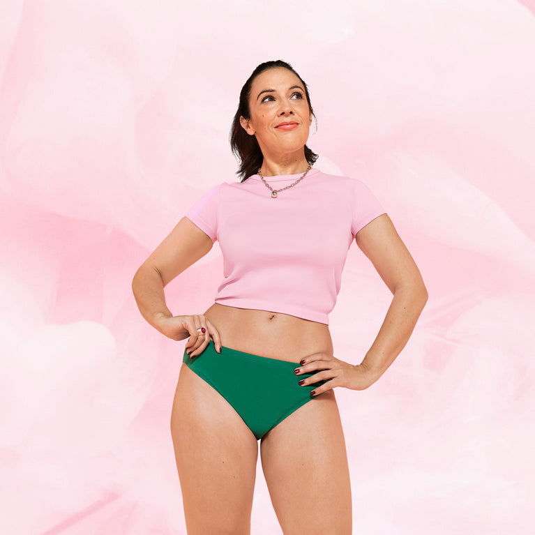 Femme portant une culotte menstruelle ComfortFit Essentielle Brazilian Moderate, offrant protection fiable et discrète. Ajustement taille haute, idéale pour confort optimal.