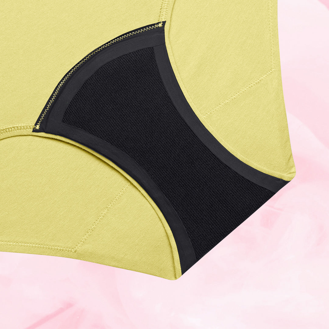 Culotte menstruelle ComfortFit Essentielle Hipster Moderate, tissu noir et jaune, offrant protection durable et ajustement parfait grâce à la technologie TriTech Performance et gousset ComfortFit.
