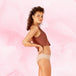Confort Premium Brazilian Moderate: femme posant en culotte menstruelle, coupe haute aux jambes, bas sur les hanches, offrant protection fiable et discrète.