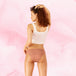 Femme portant Confort Premium Brazilian Heavy, culotte menstruelle marron haute aux jambes, offrant protection discrète avec technologie TriTech Performance.