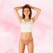 Femme portant le Confort Premium Brazilian Light, culotte menstruelle marron, taille basse, gousset multicouche TriTech, pour protection discrète et confort optimal.