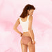 Femme en débardeur blanc portant la culotte menstruelle Confort Premium Brazilian Light de Nana™, offrant protection et confort avec technologie TriTech Performance.