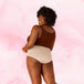 Femme souriante portant la culotte menstruelle Confort Premium High Waist Moderate, offrant confort et discrétion avec technologie TriTech Performance pour une protection prolongée.
