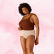 Femme portant Culotte Menstruelle Confort Premium Taille Haute, posant en sous-vêtements, mettant en avant confort et coupe élégante pour protection menstruelle optimale.