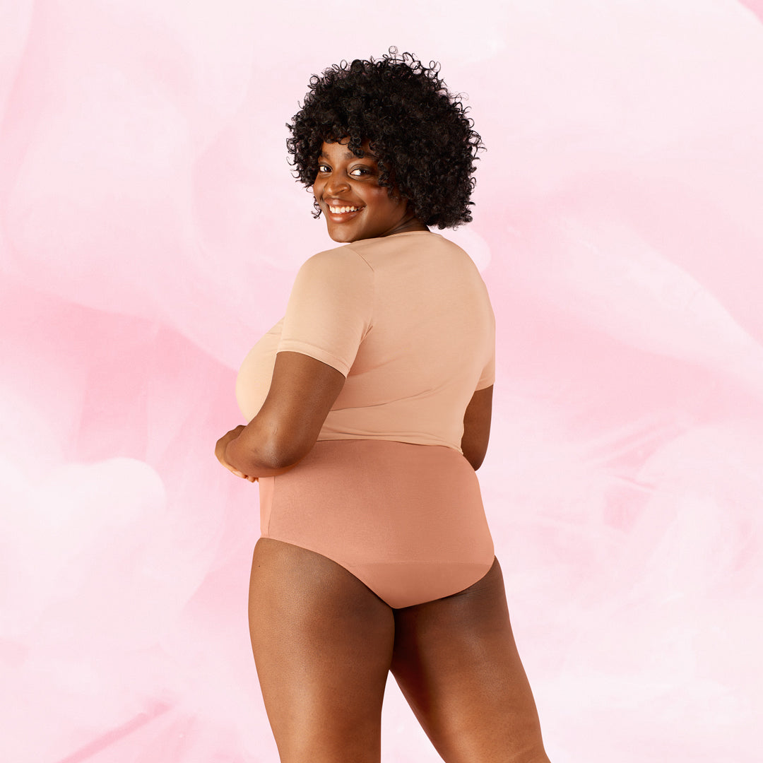 Femme portant la culotte menstruelle Confort Premium High Waist, beige, offrant confort et discrétion avec technologie TriTech pour protection jusqu'à 12 heures.