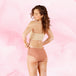 Femme portant la Confort Premium Hipster Heavy, culotte menstruelle, montrant des taches de peau, avec coupe taille basse et tissu doux pour protection et confort.