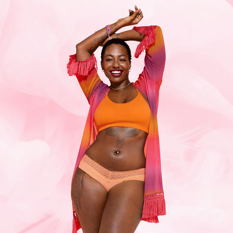 Femme souriante portant la culotte menstruelle Brazilian Moderate, confortable et absorbante, idéale pour flux modéré, offrant jusqu'à 12 heures de protection élégante.