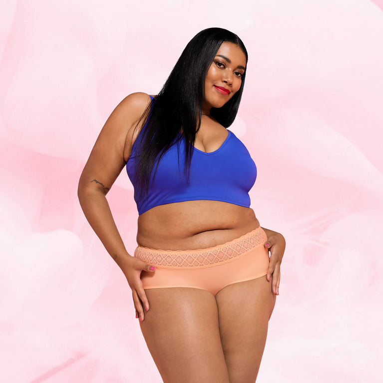 Culotte menstruelle Hipster Full Lace Heavy portée par une femme, offrant protection et confort, avec ceinture en dentelle élastiquée pour une coupe tendance.