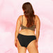 Femme de dos portant la Culotte Menstruelle Brazilian Moderate, offrant protection et confort. Design tendance avec ceinture élastiquée, idéale pour flux modéré.