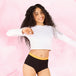 Femme portant Ados - Brief Logo Waistband Moderate, culottes menstruelles taille haute avec ceinture motif Fearless, offrant confort et protection pour adolescentes.