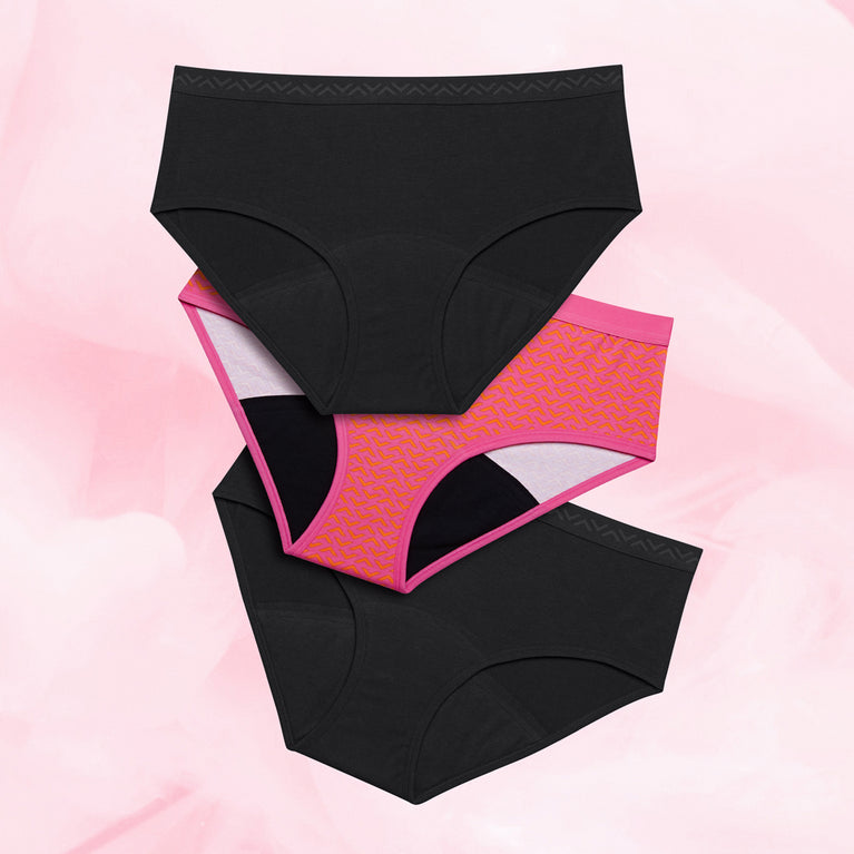 Lot de 3 culottes menstruelles Ados - Hipster Print, taille basse, avec gousset absorbant et design unique pour flux abondant, sur une table.