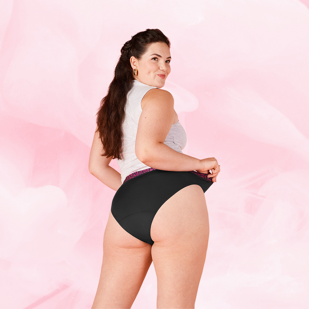 Femme ajustant la culotte ComfortFit High Leg Modéré, profil visible.