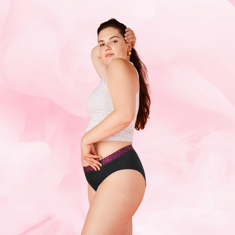 Jeune femme portant le ComfortFit High Leg Léger, posant de profil.