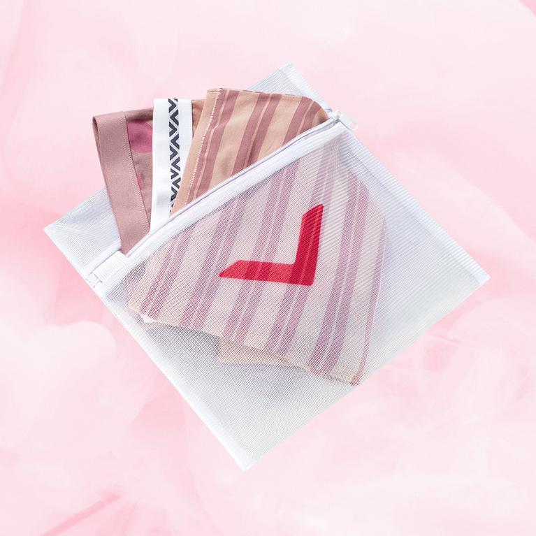 Filet à linge blanc avec flèche rouge, conçu pour protéger et laver délicatement les sous-vêtements menstruels, équipé d'une fermeture éclair pour sécuriser le contenu.