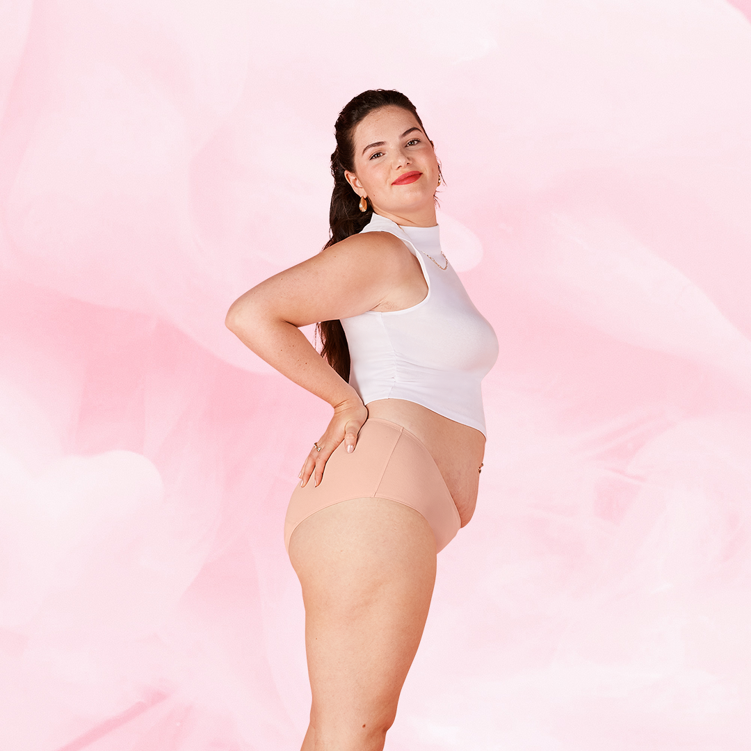 Femme en sous-vêtements, portant le hipster menstruel ComfortFit Essentielle Light, offrant protection fiable et discrète grâce à la technologie TriTech Performance.