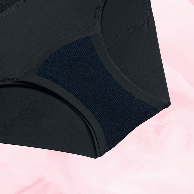 Culotte menstruelle Bikini Basic Moderate noire, confortable, ultra-absorbante, lavable, conçue pour flux modérés avec taille élastique, sur fond rose.
